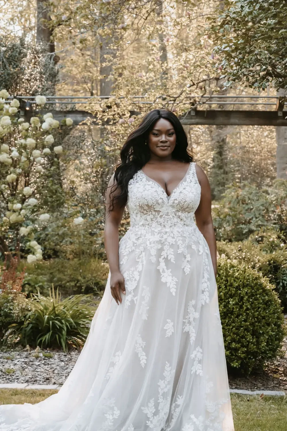model is wearing a sleeveless plus size bridal gown